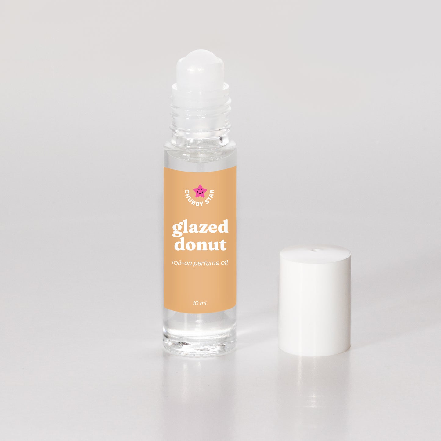 Roll-on perfume oil bottle labeled 'glazed donut' on a light gray background