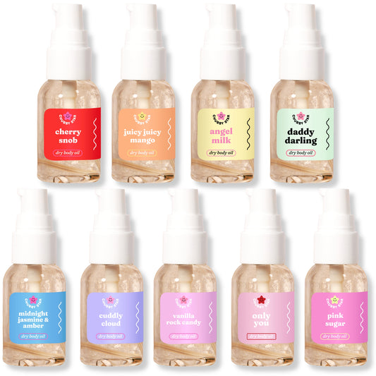 Set of 1 oz scented dry body oil mini bottles with colorful labels on a white background