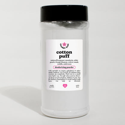 A clear plastic jar of Cotton Puff PDM Valaya scented deodorizing powder with a black lid and a white label, set against a plain white background.