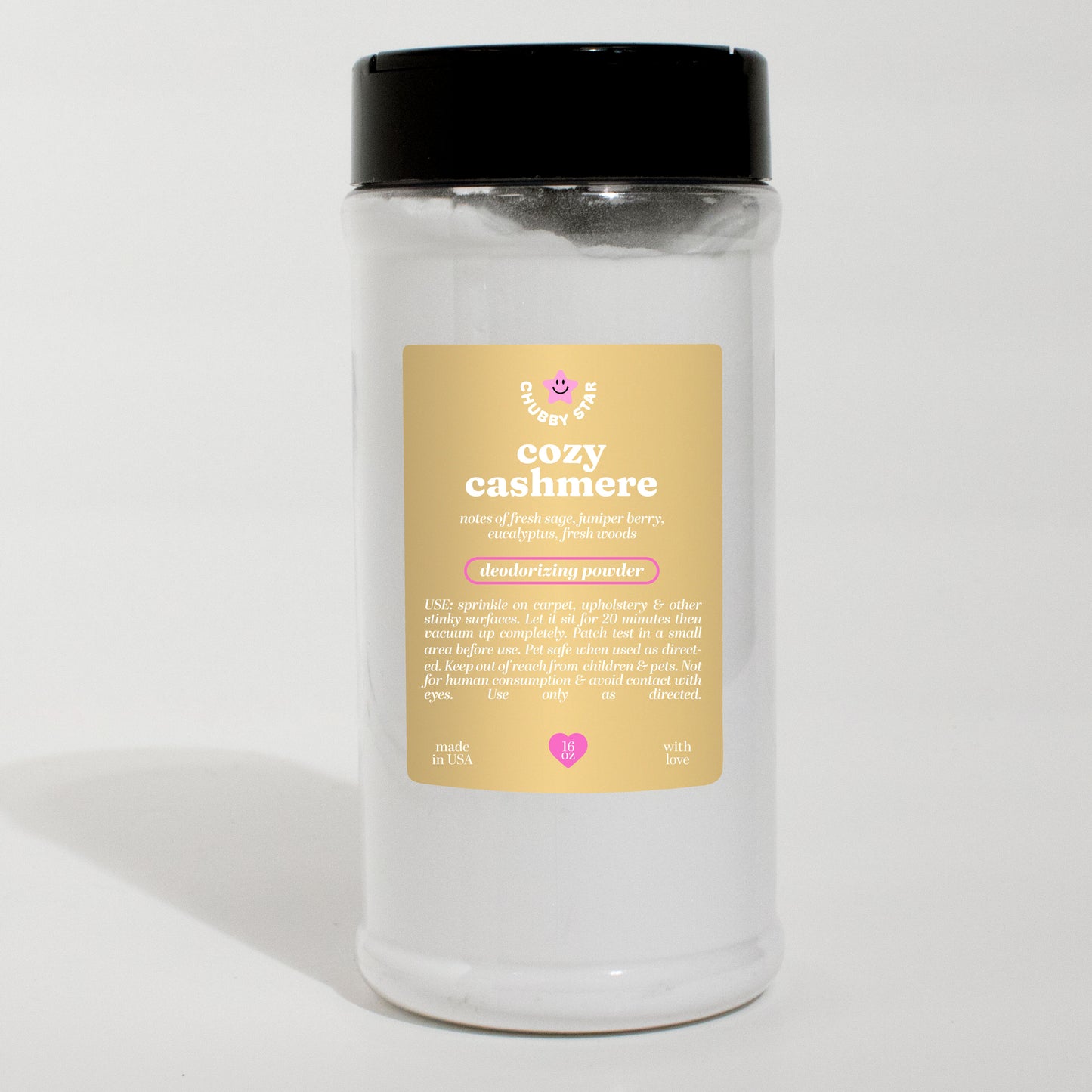 A white clear jar of 'cozy cashmere' scented carpet freshening deodorizing powder with a black lid and a beige label, set against a plain white background.