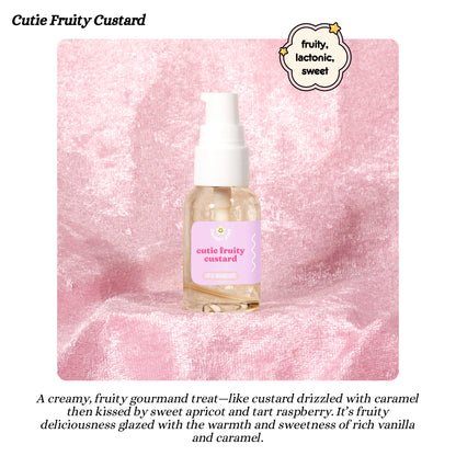 Bottle of 'Cutie Fruity Custard' body oil on a pink textured background with descriptive text.