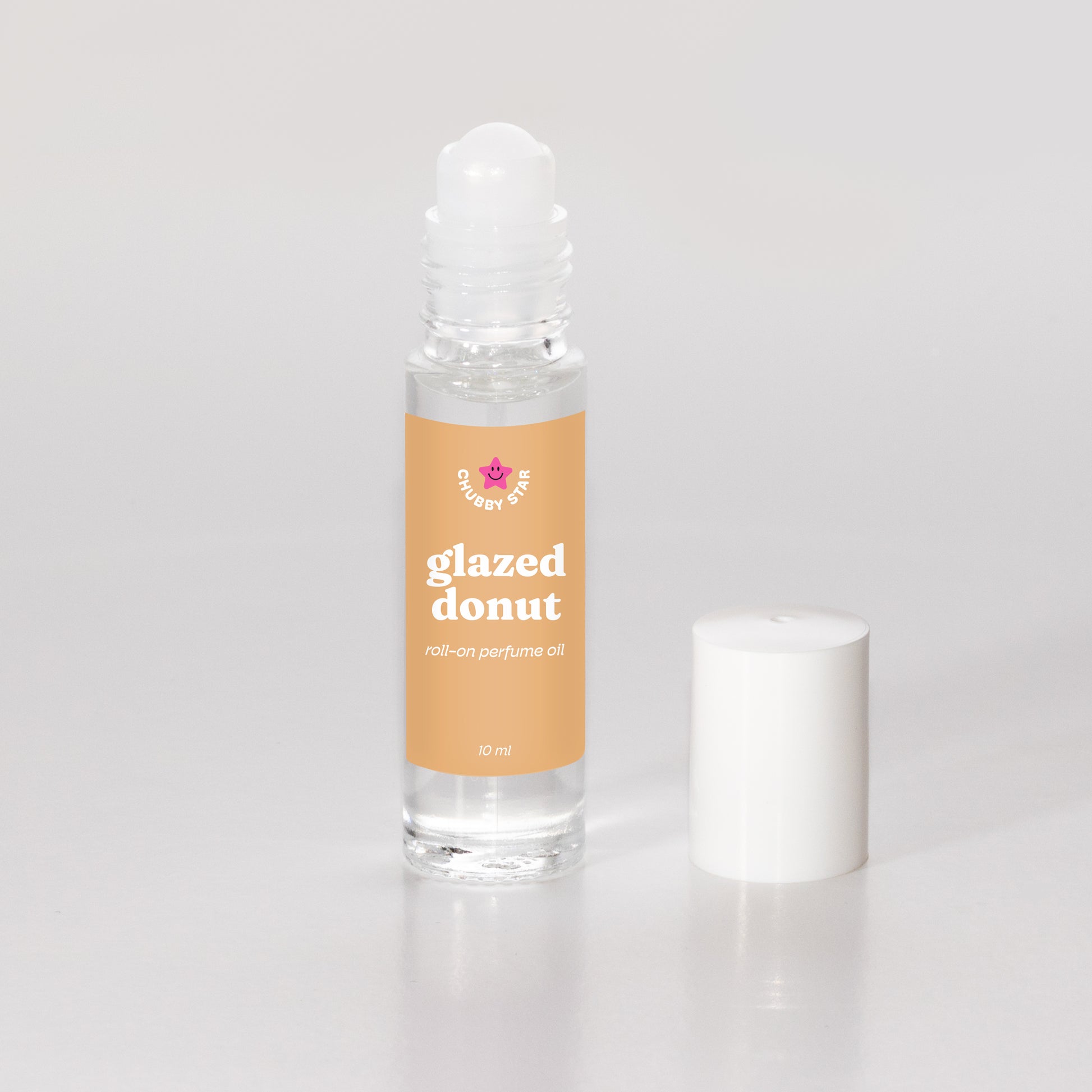 Roll-on perfume oil bottle labeled 'glazed donut' on a light gray background