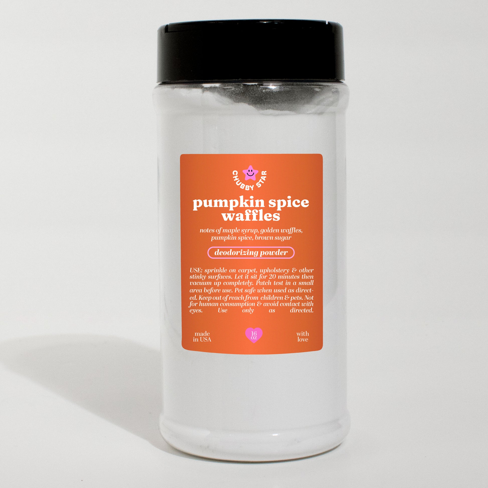 A clear plastic jar of 'pumpkin spice waffles' scented deodorizing powder carpet freshener with a black lid and an orange label, set against a plain white background.