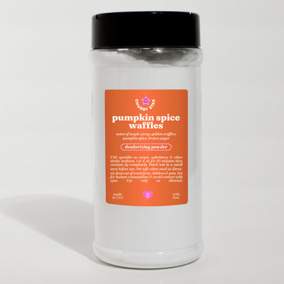 A clear plastic jar of 'pumpkin spice waffles' scented deodorizing powder carpet freshener with a black lid and an orange label, set against a plain white background.