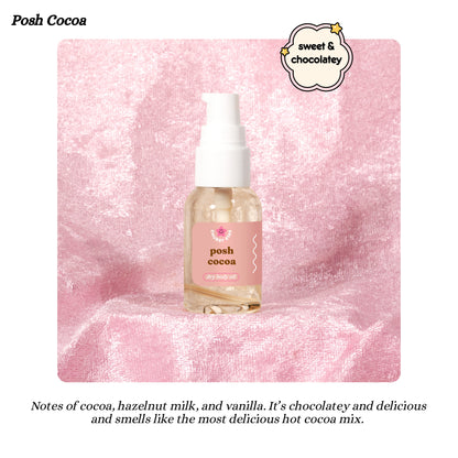 Posh Cocoa body oil bottle on a pink textured background with brand name and description text.